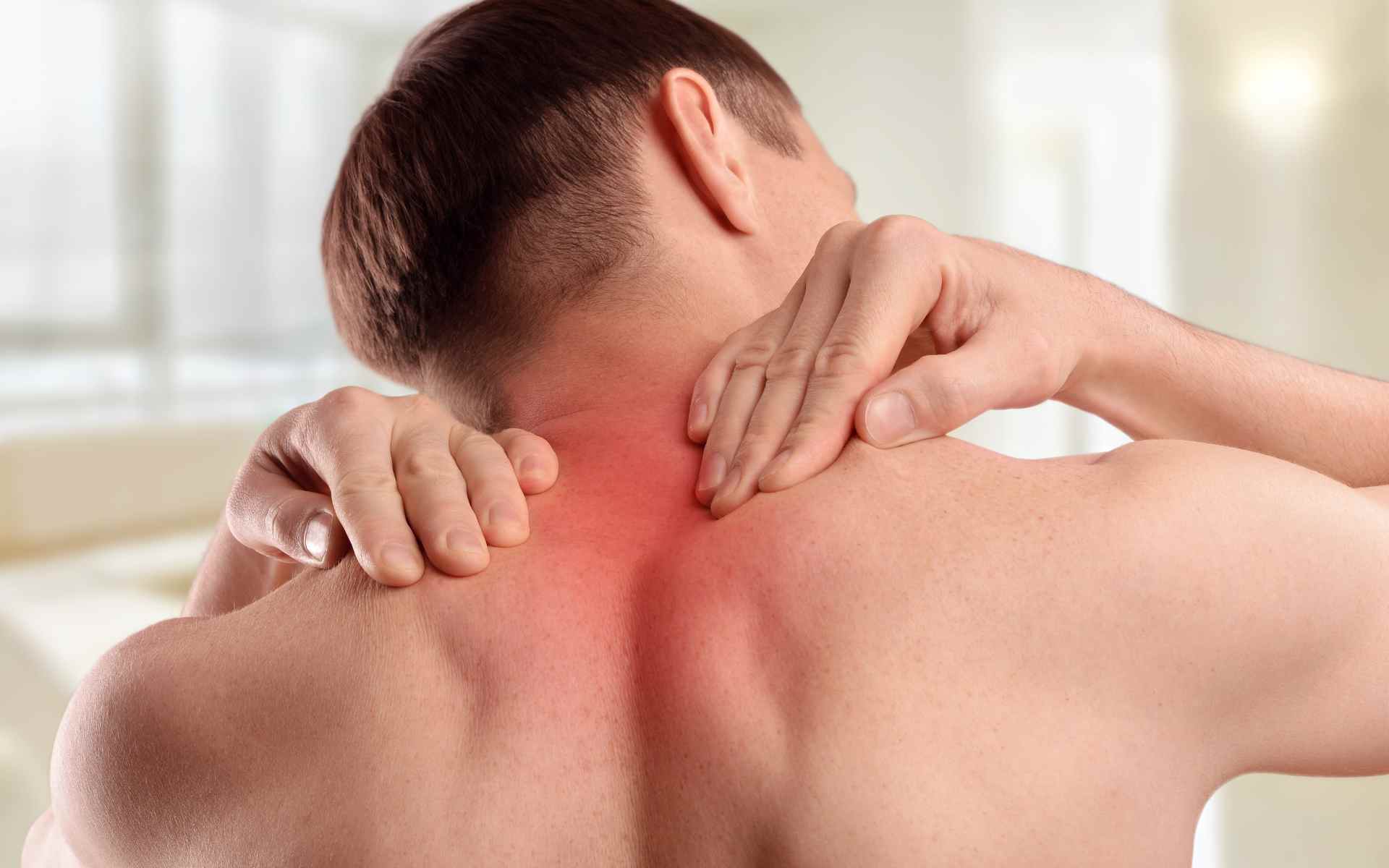 Uomo con cervicale da stress che si massaggia il collo per alleviare sintomi e dolore cervicale